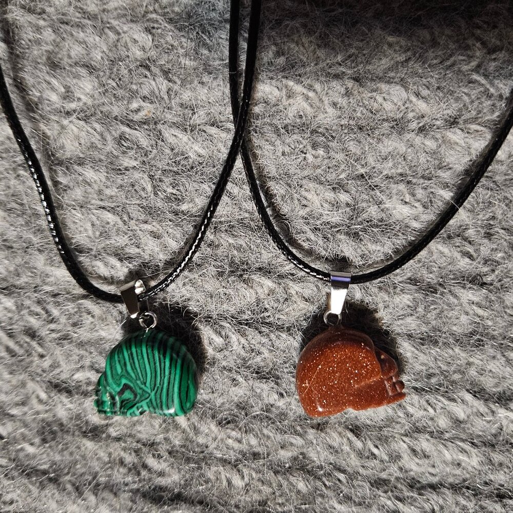 1 skull gemstone/crystal pendant, goldstone or malachite, black cord, new